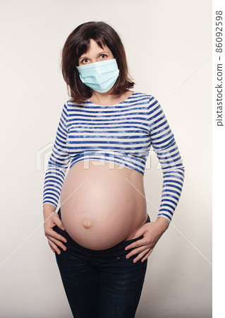 Pregnant woman brunette wearing protective mask 86092598