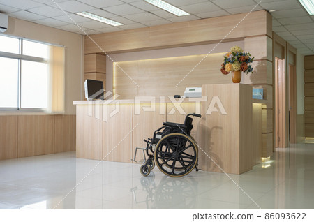 Empty modern wooden reception counter with monitor and wheelchair in the hospital 86093622