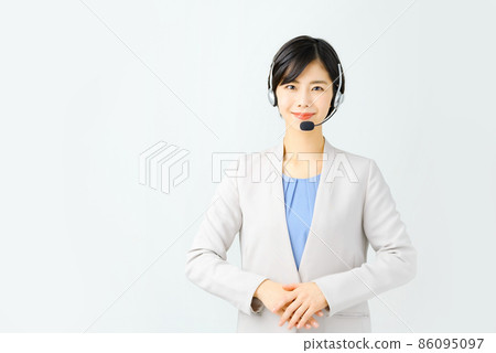 A smiling young female operator in a suit and wearing a headset A smiling young female operator in a suit and wearing a headset 86095097