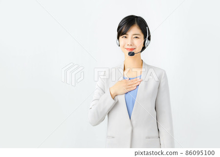 A smiling young female operator in a suit and wearing a headset 86095100