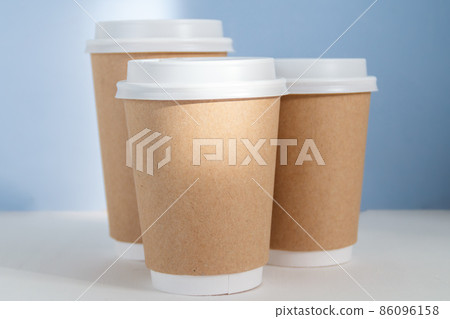 group of paper cups against blue background, greenwashing concept group of paper cups against blue background, greenwashing concept 86096158