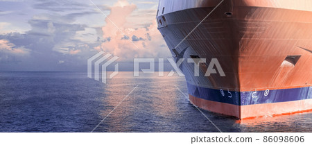 Close up of large merchant cargo ship in the middle of the ocean underway. Performing cargo export and import operations. Close up of large merchant cargo ship in the middle of the ocean underway. Performing cargo export and import operations. 86098606
