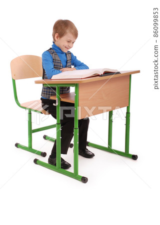 Boy sitting at a school desk 86099853