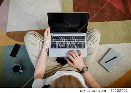 Young Male Using Laptop Top View 86102402