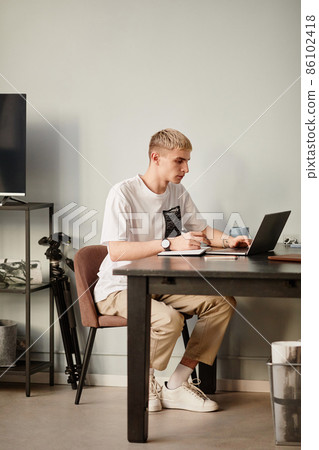 Modern Young Man Studying at Home Modern Young Man Studying at Home 86102418
