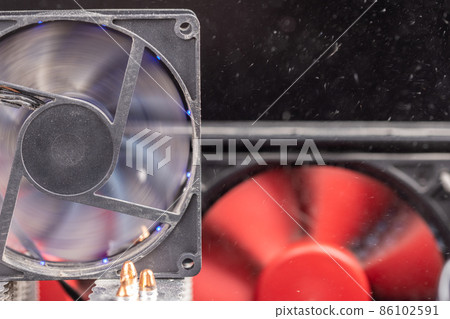 spinning 90 mm pc fan close-up with thick layer of dust and flying airborne dust particles 86102591