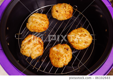 cooked chicken meatballs on steel grille in opened airfryer cooked chicken meatballs on steel grille in opened airfryer 86102683