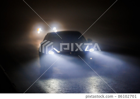 two blurred cars moving on empty night foggy road two blurred cars moving on empty night foggy road 86102701