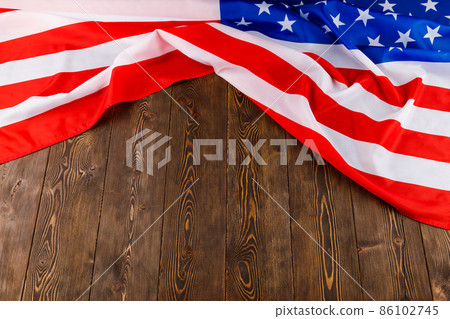 crumpled usa flag on flat textured wooden surface background 86102745