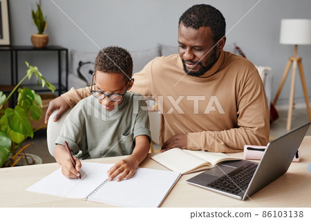 Father and Son Studying at Home Together 86103138