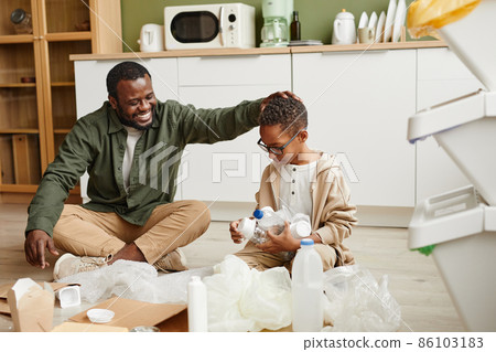 Smiling Father and Son Sorting Plastic at Home Smiling Father and Son Sorting Plastic at Home 86103183