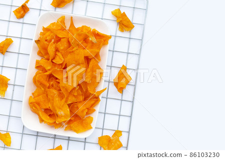 Sweet potato chips on white background. Sweet potato chips on white background. 86103230