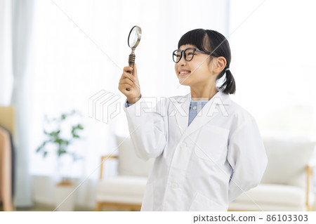 一個穿白大衣的女孩在客廳裡看著放大鏡 86103303