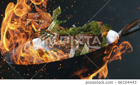 Freeze Motion of Wok Pan and Flying Ingredients in the Air. Freeze Motion of Wok Pan and Flying Ingredients in the Air. 86104443