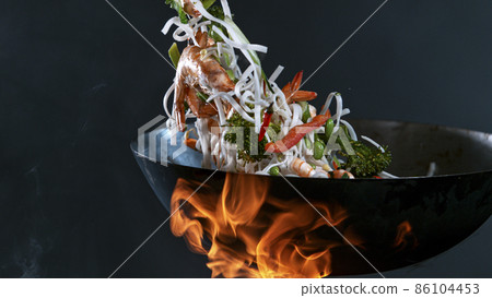 Freeze Motion of Wok Pan and Flying Ingredients in the Air. 86104453