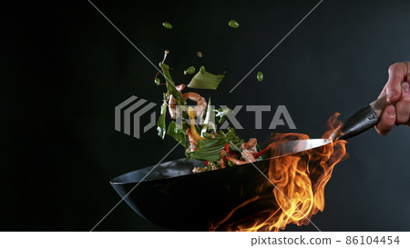 Freeze Motion of Wok Pan and Flying Ingredients in the Air. 86104454