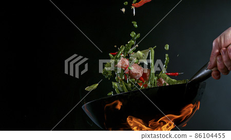 Freeze Motion of Wok Pan and Flying Ingredients in the Air. 86104455