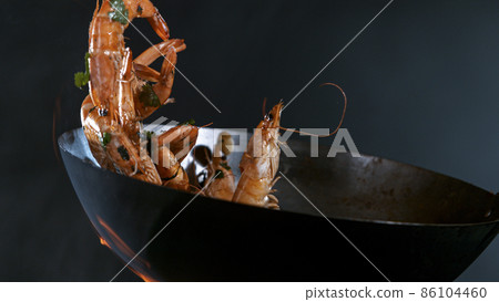 Freeze Motion of Wok Pan and Flying Ingredients in the Air. Freeze Motion of Wok Pan and Flying Ingredients in the Air. 86104460