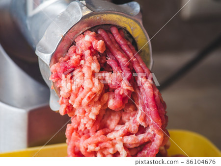 Closeup of minced meat coming out from grinder. Healthy homemade minced meat 86104676