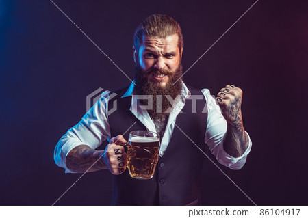 Emotional bearded man holds tasty draft beer in hand while gesturing. Drinking, October fest concept Emotional bearded man holds tasty draft beer in hand while gesturing. Drinking, October fest concept 86104917
