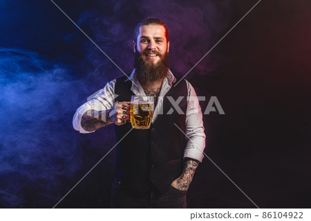 Smilling bearded man holds tasty draft beer in hand. Drinking, October fest concept. Smilling bearded man holds tasty draft beer in hand. Drinking, October fest concept. 86104922