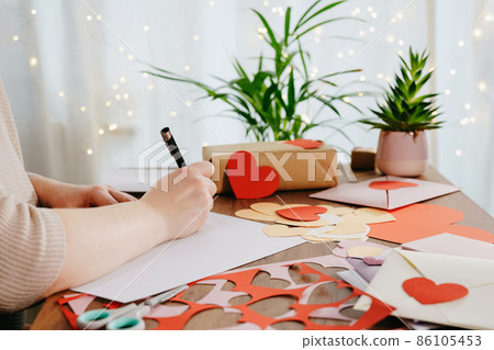 Woman writing a letter by hand for Valentines Day Woman writing a letter by hand for Valentines Day 86105453