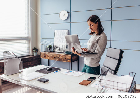 Woman takes her laptop away after work Woman takes her laptop away after work 86105753
