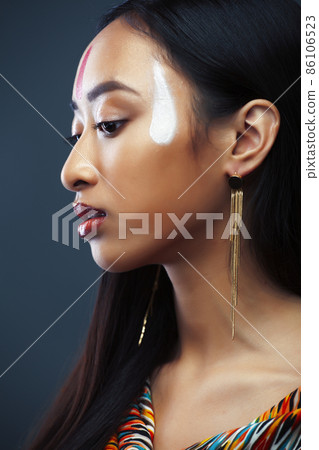 young pretty south asian girl posing in studio on grey background, lifestyle people concept young pretty south asian girl posing in studio on grey background, lifestyle people concept 86106523
