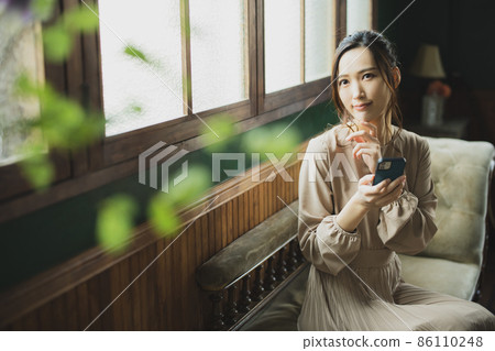 A woman watching a smartphone 86110248