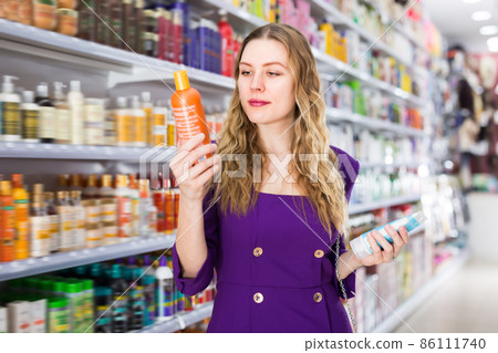 Ordinary young female choosing hair care products 86111740