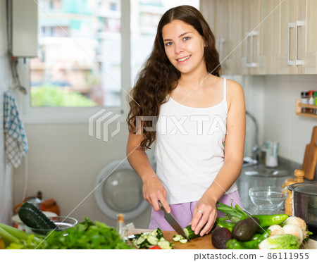 Housewoman cooking vegetable salad at kitchen Housewoman cooking vegetable salad at kitchen 86111955