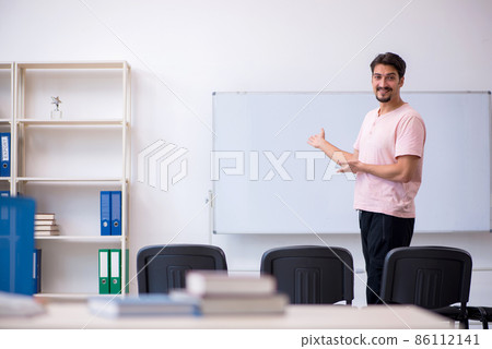 Young male teacher in the classroom during pandemic 86112141