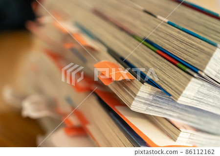 Sticky notes on stacked comic books 86112162