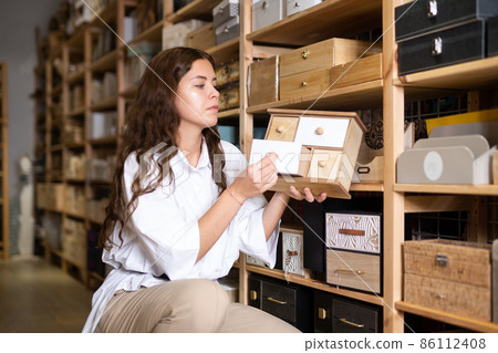 Woman choosing jewelry storage box at shop Woman choosing jewelry storage box at shop 86112408