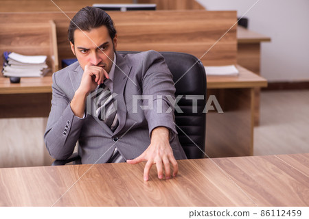 Young businessman employee sitting in the office 86112459