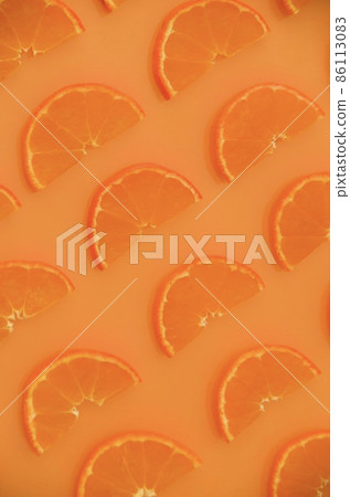 Half slices of mandarin oranges lined up on one side in vertical composition 86113083