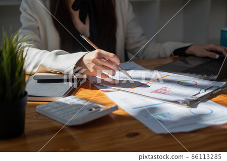 Financial Businesswoman analyze the graph of the company's performance to create profits and growth, Market research reports and income statistics, Financial and Accounting concept 86113285