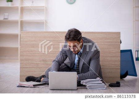 Young male employee working overtime in the office Young male employee working overtime in the office 86113378