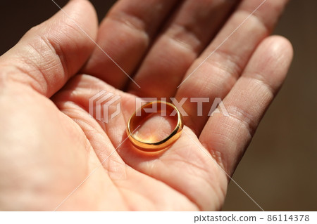 An old pure gold ring on the palm of my hand, a keepsake from my grandmother 86114378