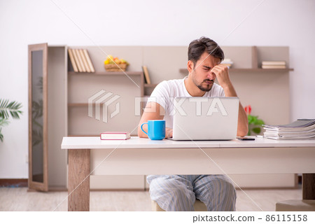 Young male employee working from home during pandemic Young male employee working from home during pandemic 86115158