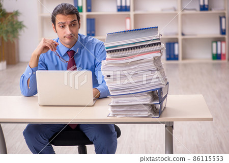 Young male employee unhappy with excessive work Young male employee unhappy with excessive work 86115553