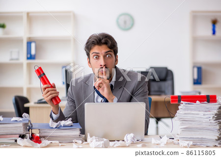 Young male employee and too much work in the office Young male employee and too much work in the office 86115805