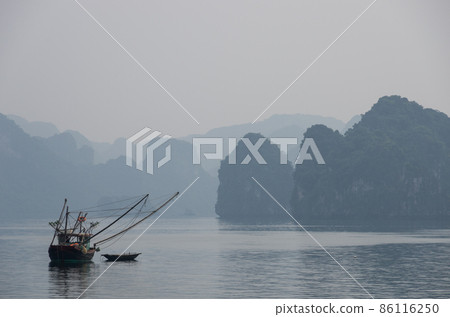 A small boat fishing in Halong Bay 86116250