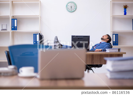 Young male employee working in the office Young male employee working in the office 86116536