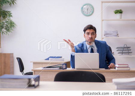 Young male employee being unhappy with excessive work Young male employee being unhappy with excessive work 86117291