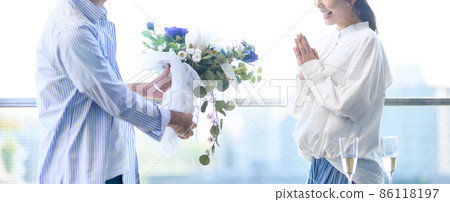 A man handing a bouquet on an anniversary 86118197