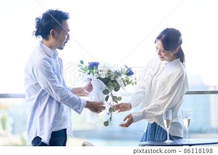 A man handing a bouquet on an anniversary 86118198