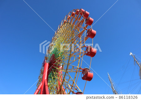 A view of the dark blue sky and the mast of the Ferris wheel and sailing ship 86118326