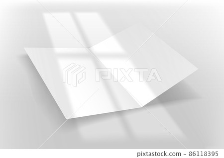 White paper booklet on a table with light of the window shadow overlay 86118395