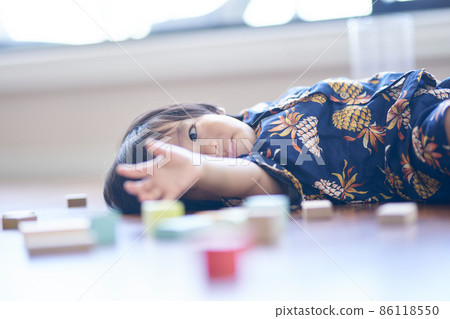 A moody one-year-old lying on the floor 86118550